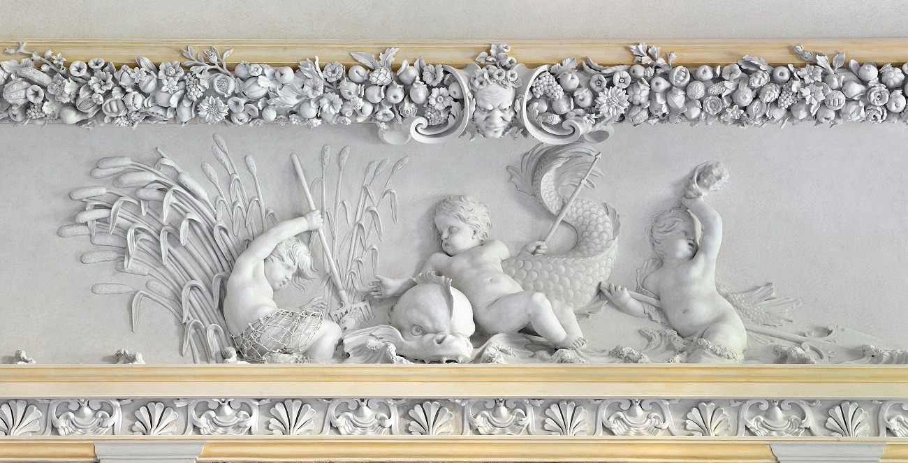 Płaskorzeźba i dekoracja sztukatorska fasety Wielkiej Sieni pałacu w Wilanowie. Środkowy pas przedstawia małe putta wyłaniające się z wody, wraz z wilkiem morskim. Jedno z nich trzyma w ręce ostrą dzidę. Powyżej pas ozdobny z kwiatami i roślinami. Jest to alegoria żywiołu wody. 