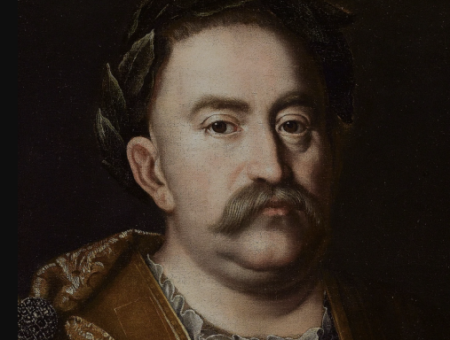 Portret olejny króla Jana III Sobieskiego. Król patrzy poważnie przed siebie. Ma na głowie wieniec laurowy, ubrany jest w zbroję antyczną. 