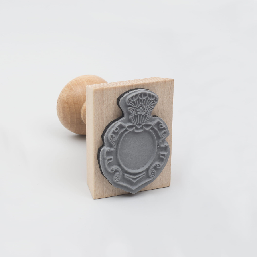 Drewniany stempel z pieczątką w kształcie herbu. 
