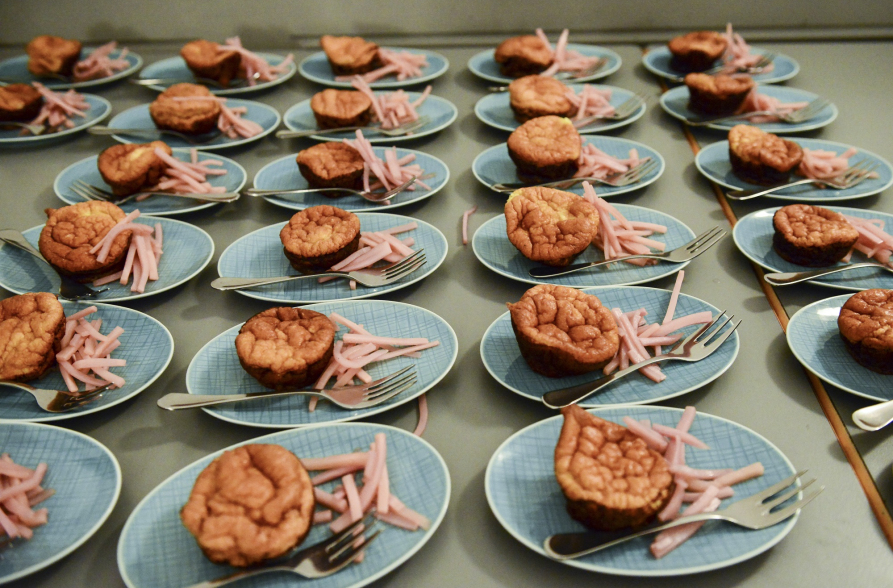 Na stole leżą talerze, na których położono danie w formie babeczki i widelczyk.