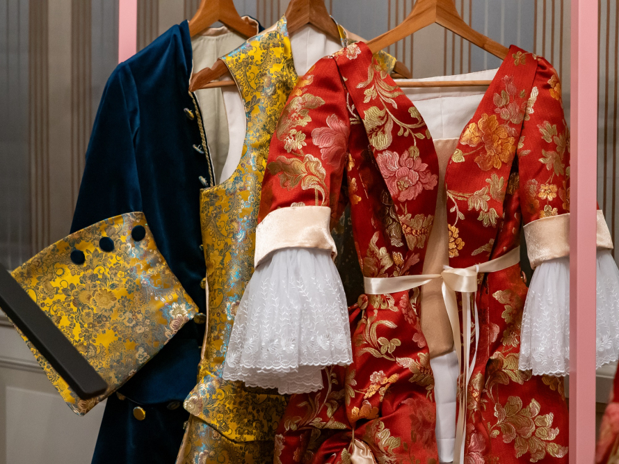 Stroje historyczne wiszące na wieszakach.